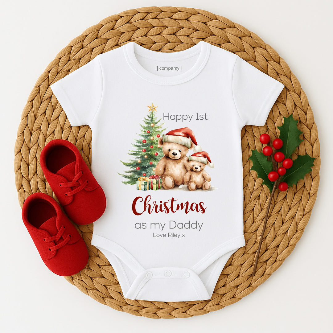 White baby onesie with Christmas design and red shoes on a woven mat