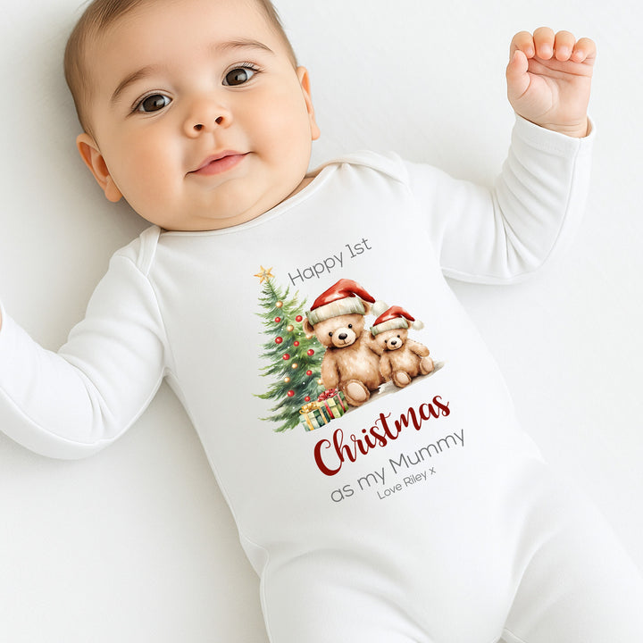 Baby wearing a white onesie with Christmas-themed design and text.