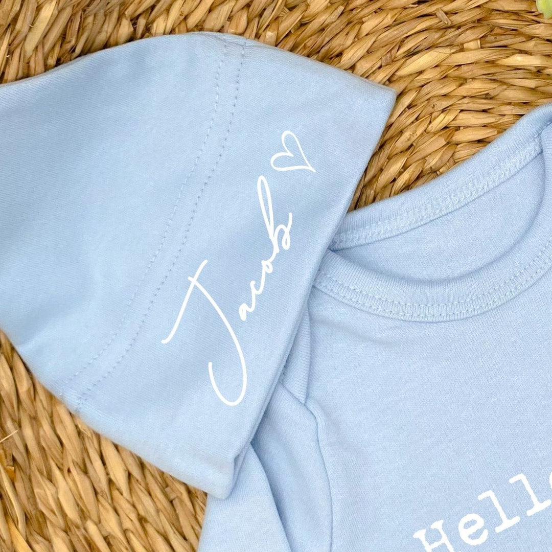 a personalised blue baby hat that says 'Jacob'