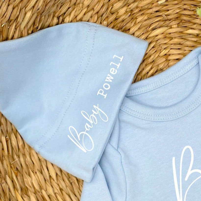 a personalised blue baby hat that says 'Baby Brown'