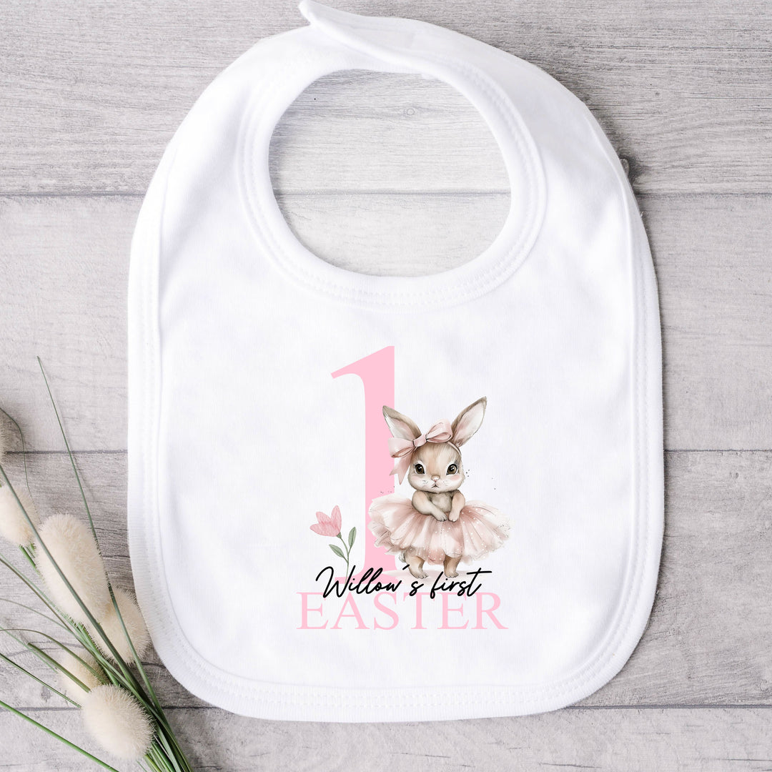 Personalised white Easter baby bib that says 'Willow's first Easter'. This design features a big pink 1 with a ballerina bunny standing next to it