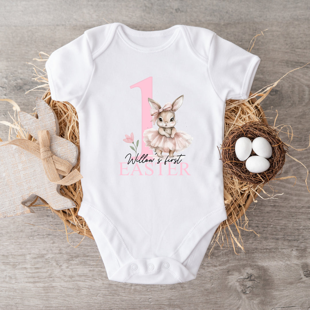 Personalised white Easter baby vest that says 'Willow's first Easter'. This design features a big pink 1 with a ballerina bunny standing next to it