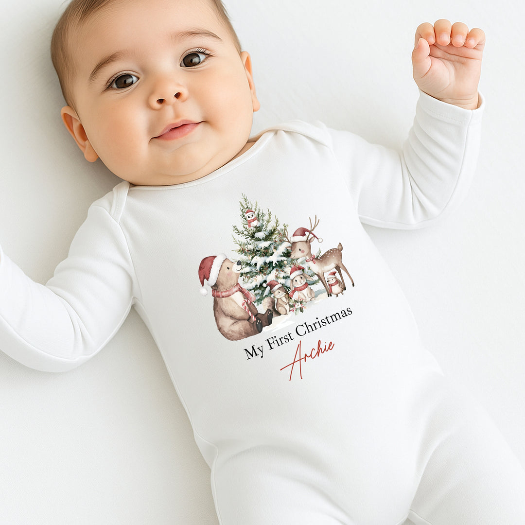 Baby wearing a white onesie with Christmas-themed design and text on a white background