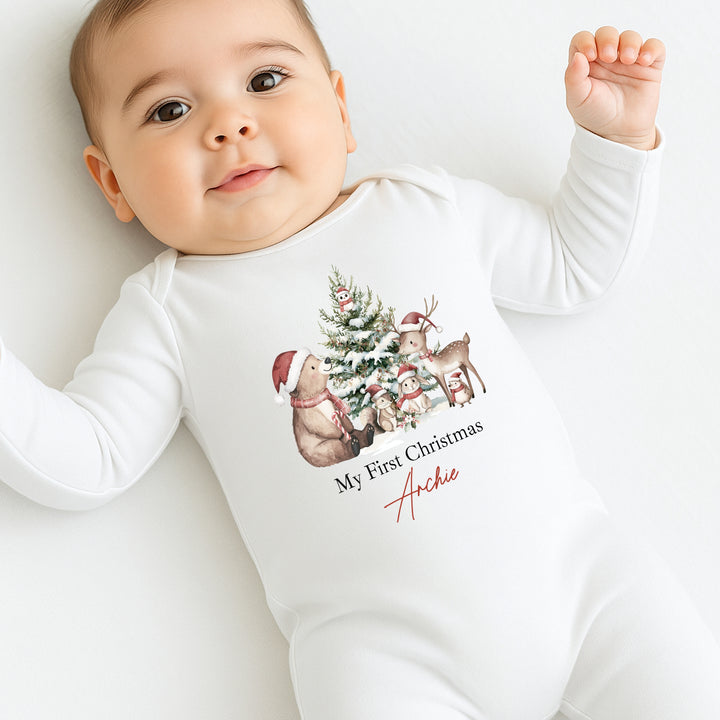 Baby wearing a white onesie with Christmas-themed design and text on a white background