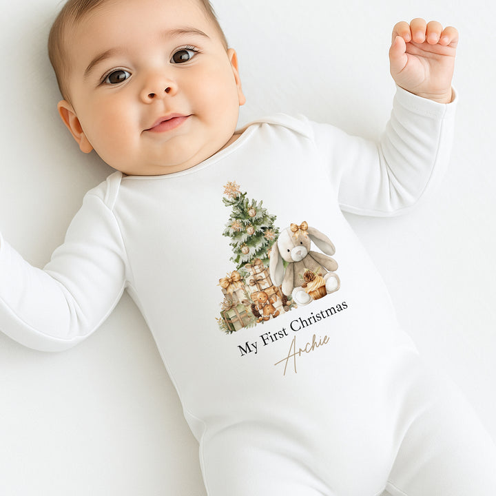 Baby wearing a white onesie with a Christmas design and text on a white background