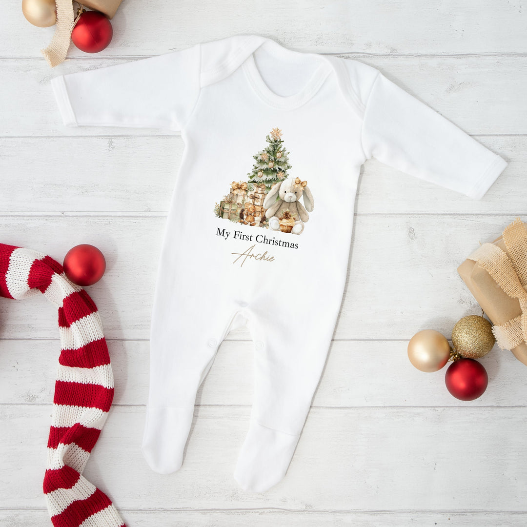 Baby onesie with Christmas design and decorations on a white wooden surface