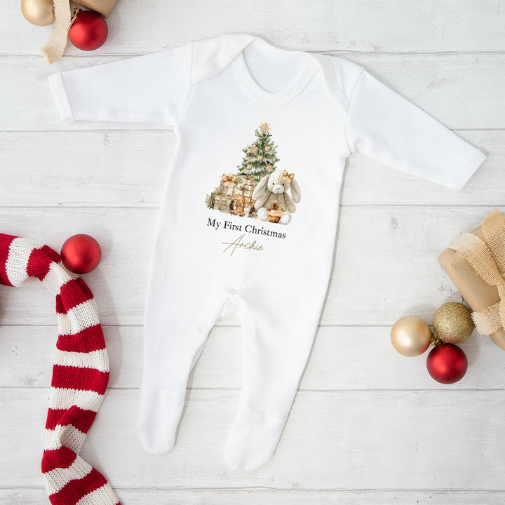 Baby onesie with Christmas design and decorations on a white wooden surface