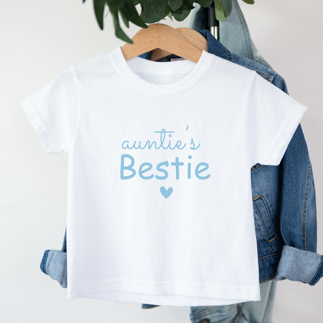 White t-shirt with 'auntie's Bestie' text on a hanger with denim jacket.