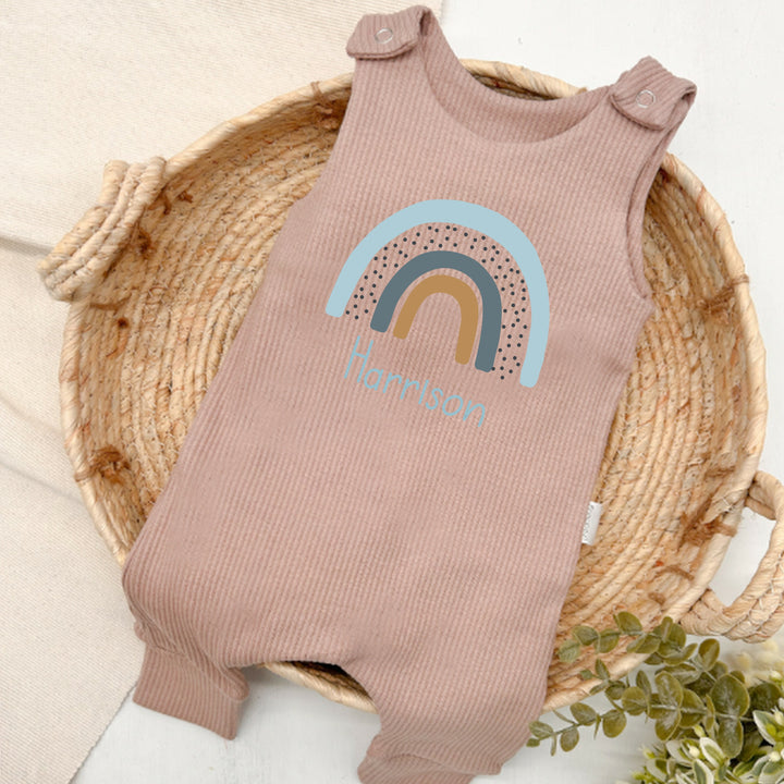 Personalised brown ribbed dungarees that say 'Harrison'. This design features a blue rainbow