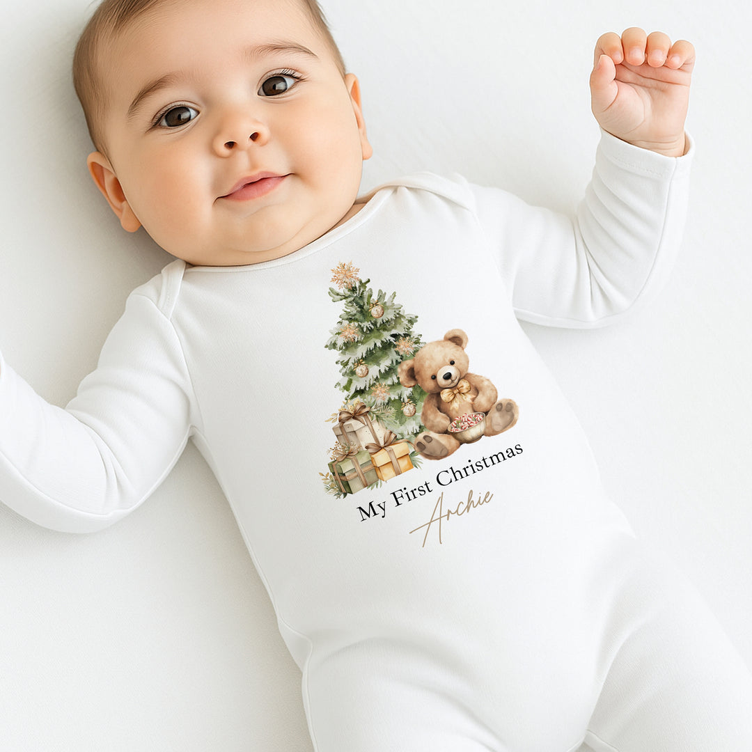 Baby wearing a white onesie with a Christmas design and text on a white background