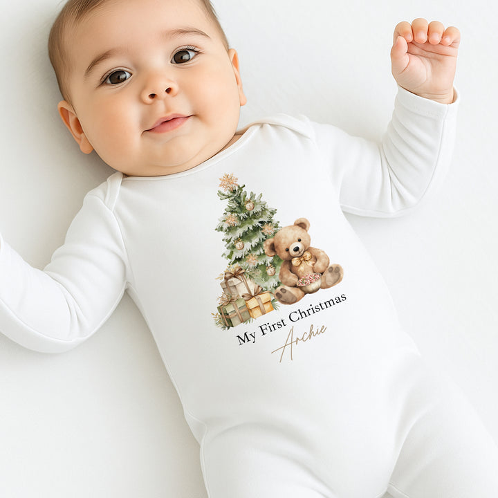 Baby wearing a white onesie with a Christmas design and text on a white background
