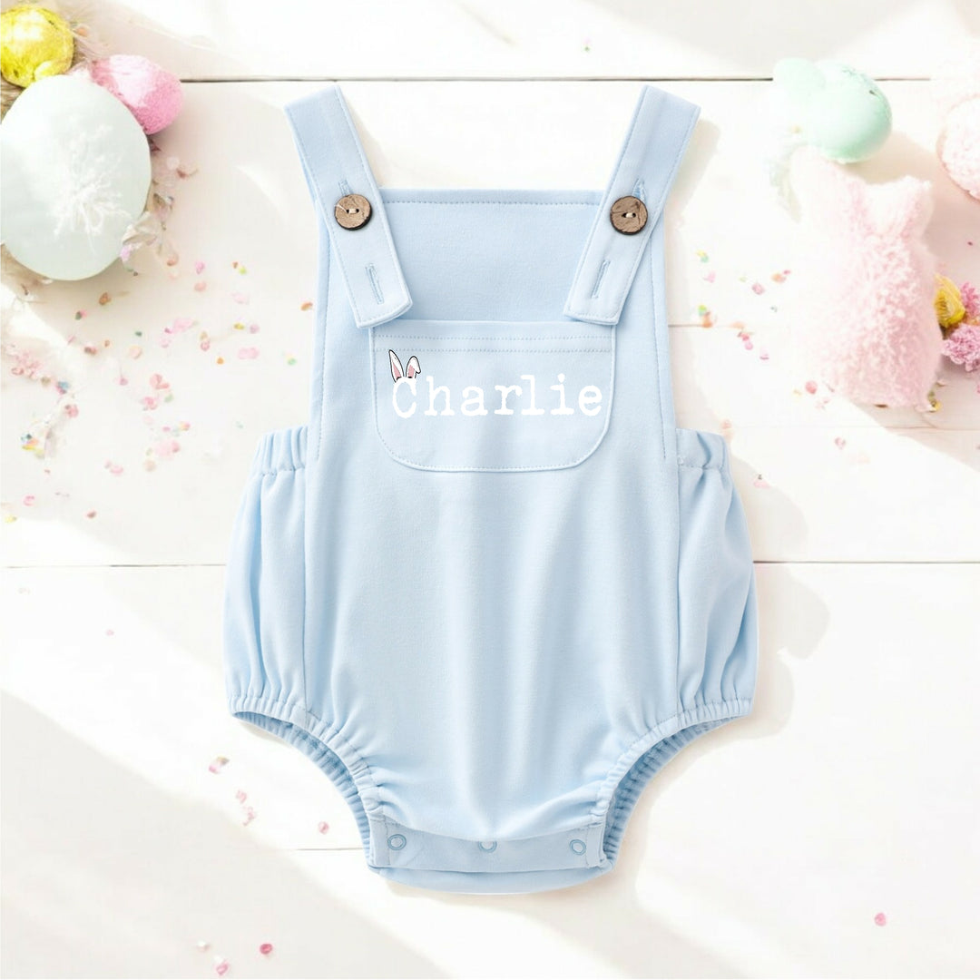 Persoanlised blue Easter dungarees that say 'Charlie'.