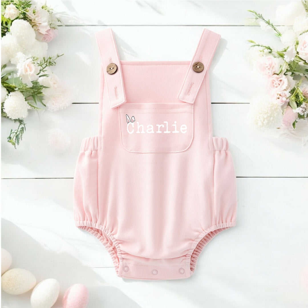 Persoanlised pink Easter dungarees that say 'Charlie'.