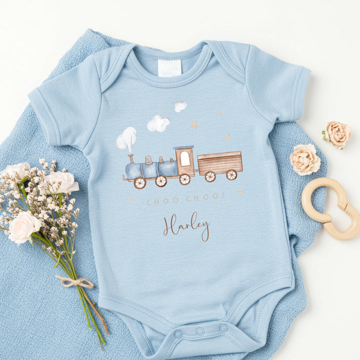 a personalised blue baby vest that says 'Choo Choo! Harley'. This design features a blue steam train