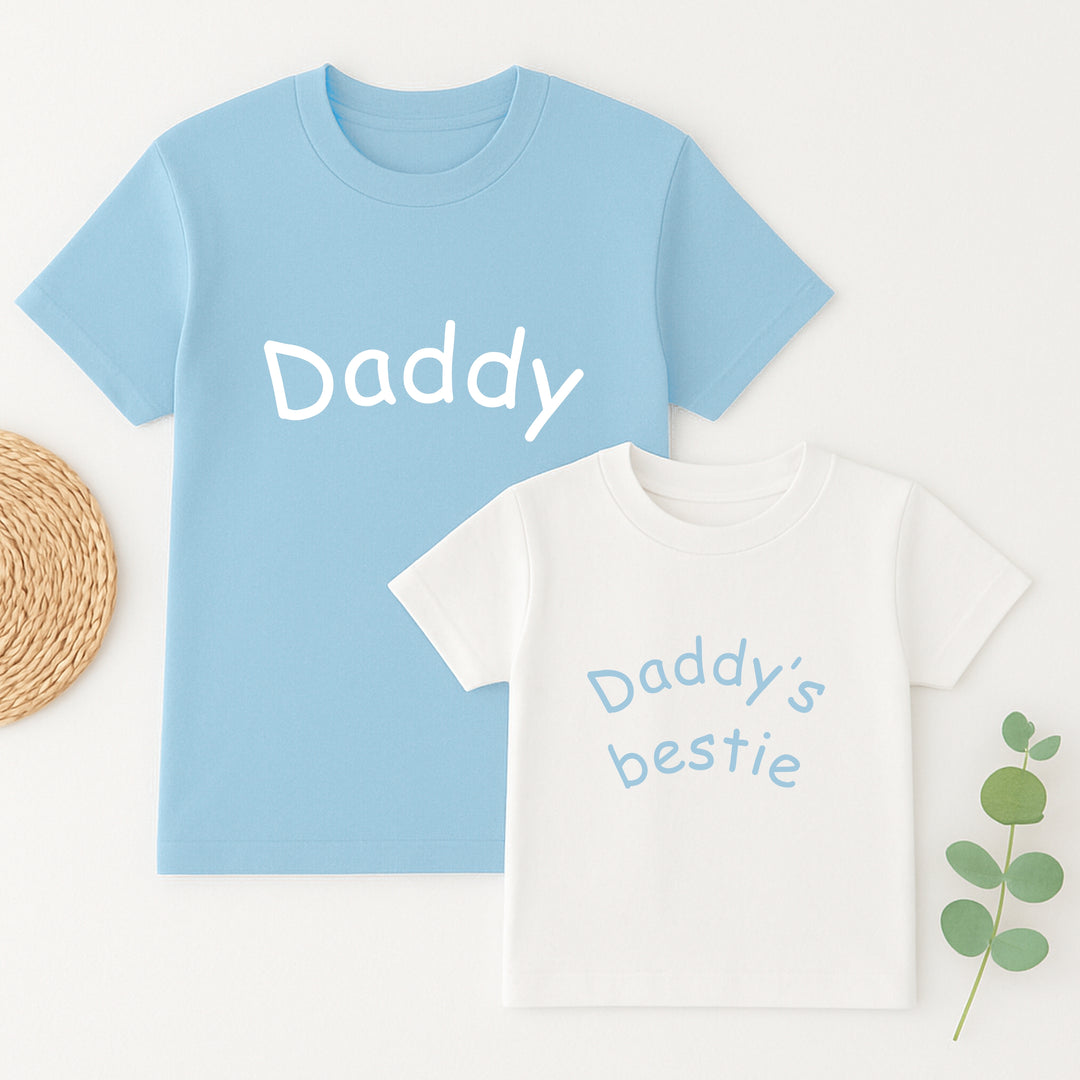 Light blue t-shirt with 'Daddy' text and white t-shirt with 'Daddy's bestie' text on a light background.
