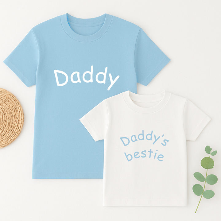Light blue t-shirt with 'Daddy' text and white t-shirt with 'Daddy's bestie' text on a light background.