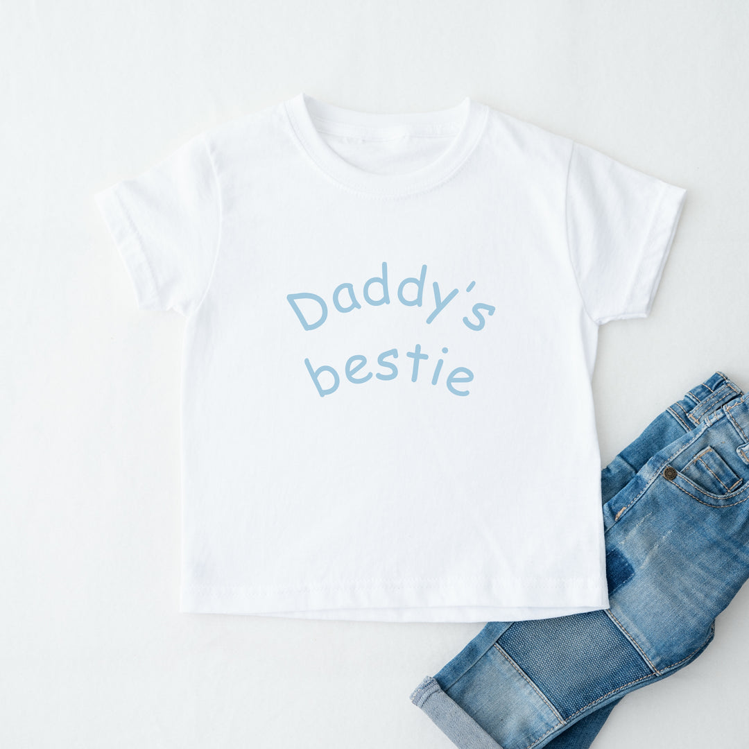 White t-shirt with 'Daddy's bestie' text and blue jeans on a white background