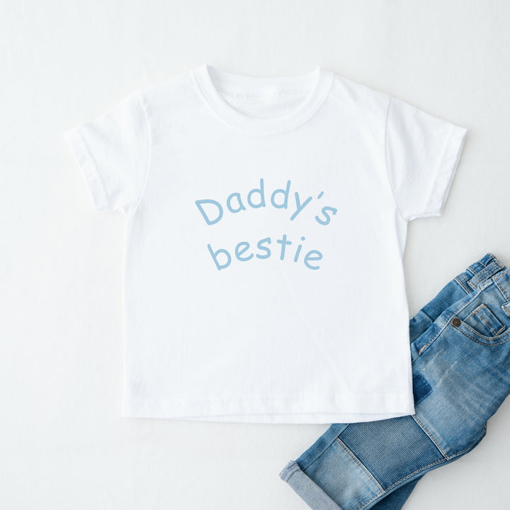 White t-shirt with 'Daddy's bestie' text and blue jeans on a white background