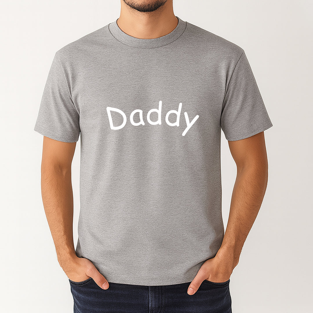 Gray t-shirt with 'Daddy' printed on it worn by a person against a white background