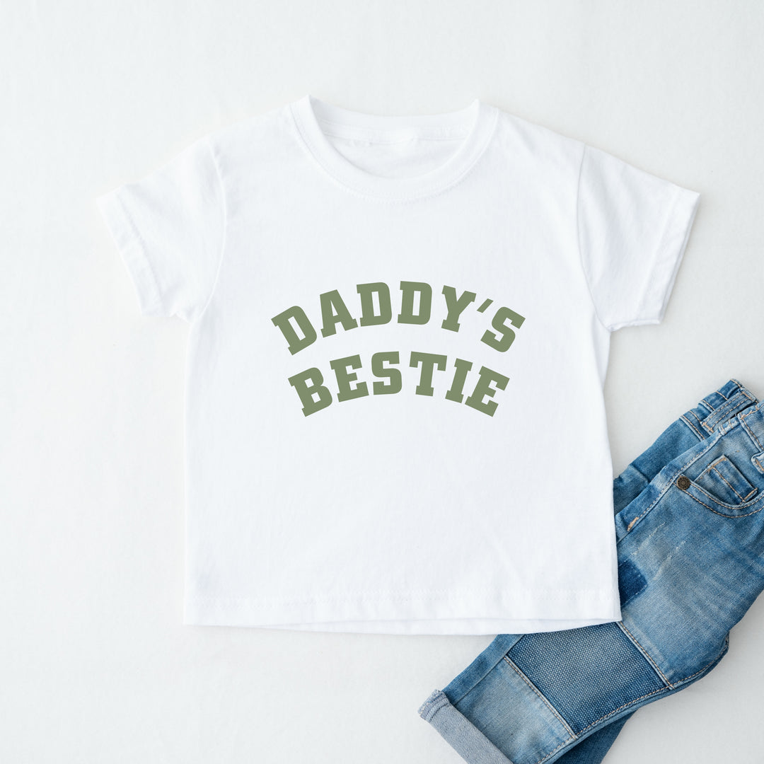 White t-shirt with 'Daddy's Bestie' text and blue jeans on a white background