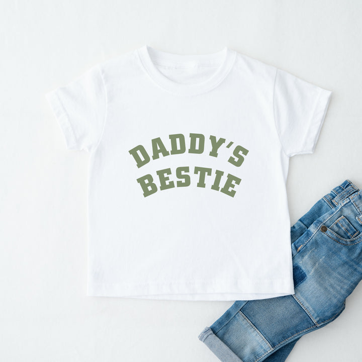 White t-shirt with 'Daddy's Bestie' text and blue jeans on a white background