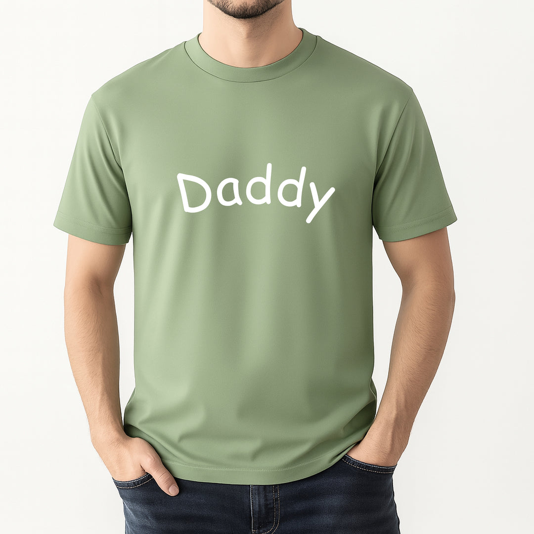 Person wearing a green t-shirt with 'Daddy' printed on it against a white background