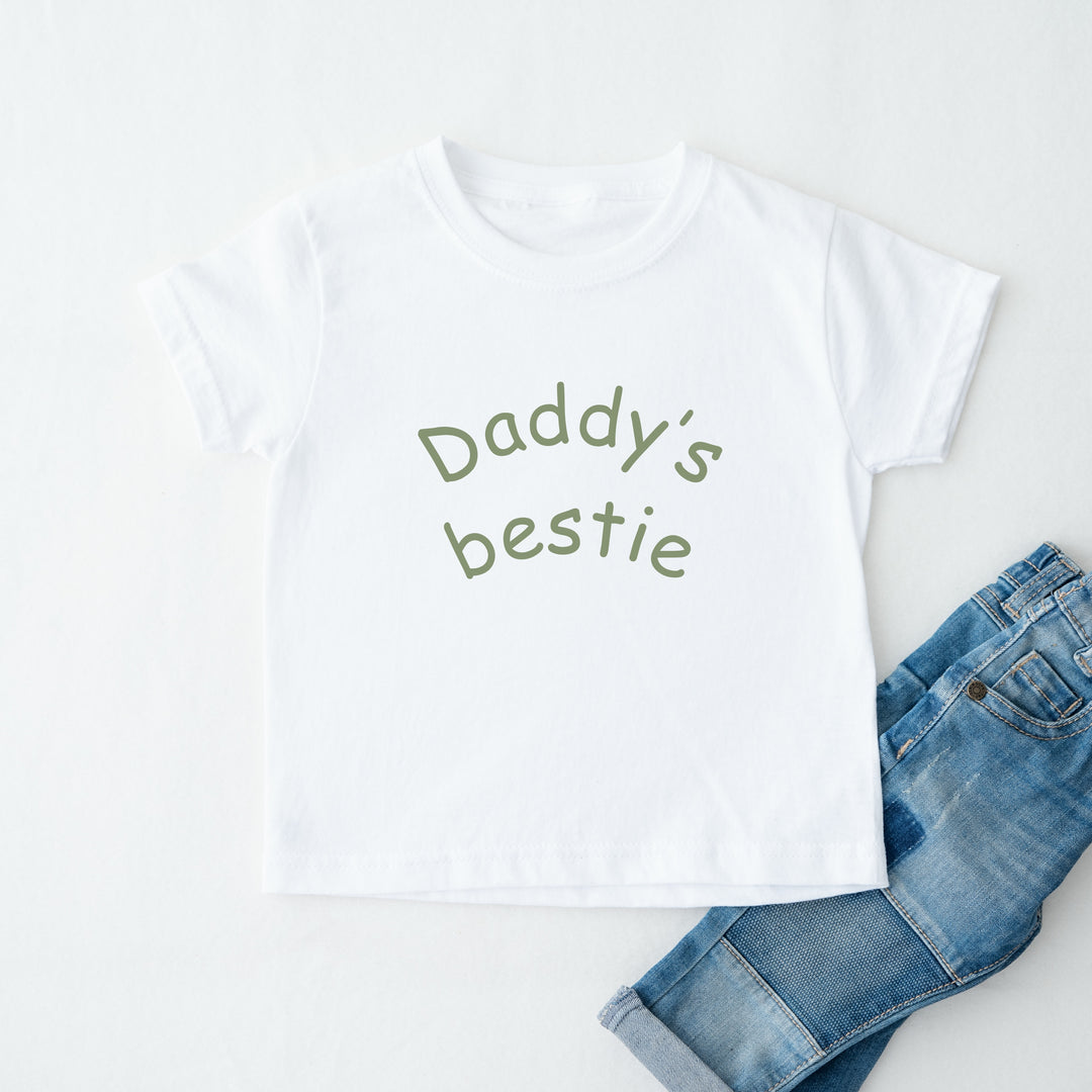 White t-shirt with 'Daddy's bestie' text and blue jeans on a white background