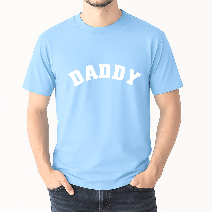 Light blue t-shirt with 'DADDY' text worn by a person on a white background