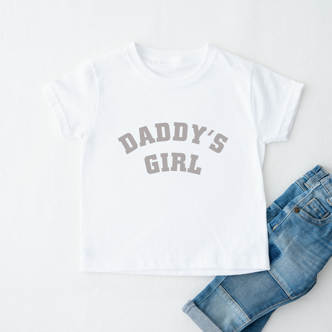 White t-shirt with 'Daddy's Girl' text and blue jeans on a white background