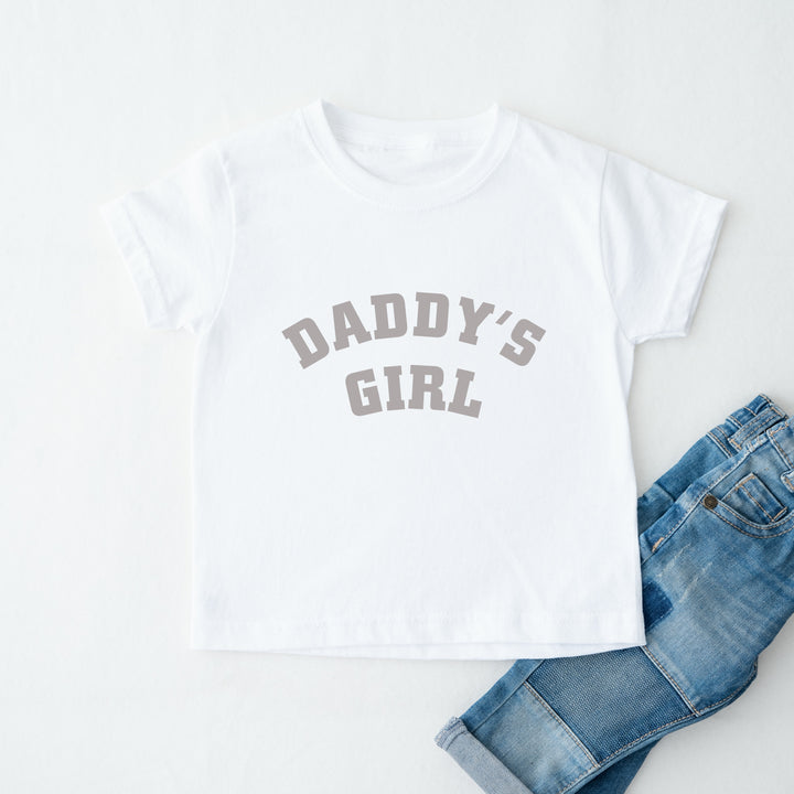 White t-shirt with 'Daddy's Girl' text and blue jeans on a white background