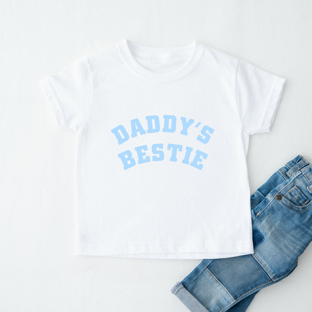 White t-shirt with 'Daddy's Bestie' text and blue jeans on a white background