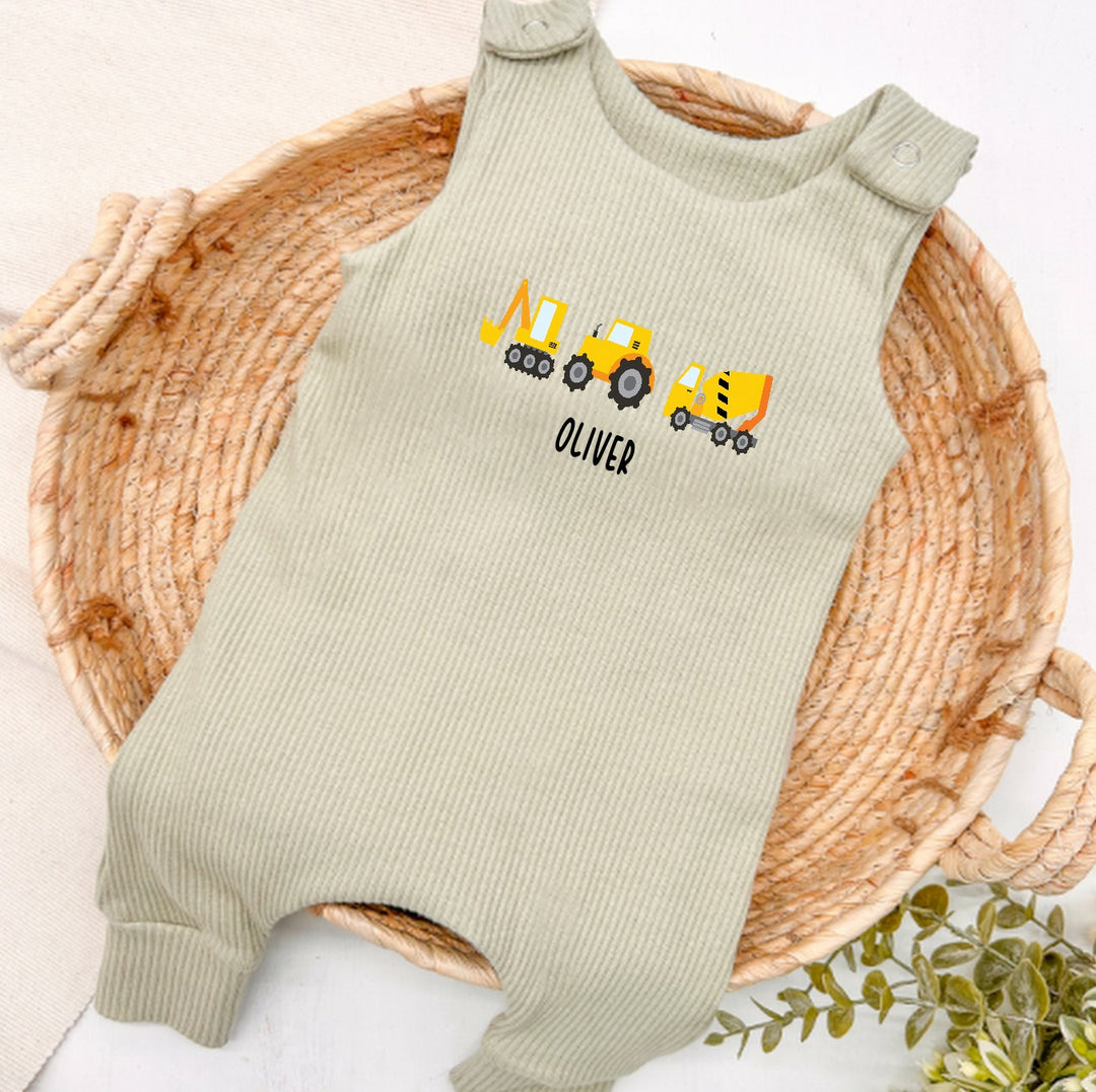Personalised sage green ribbed dungarees that say 'Oliver'. This design features 3 diggers