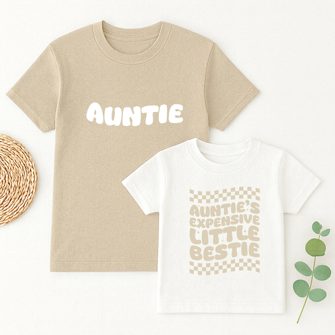 Beige t-shirt with 'Auntie' text and white t-shirt with 'Auntie's expensive little bestie' text on a white background.