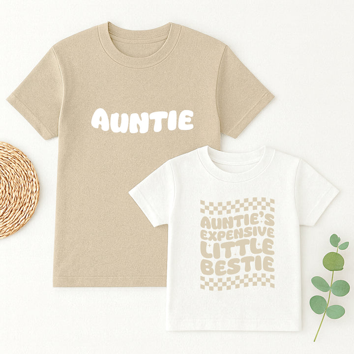 Beige t-shirt with 'Auntie' text and white t-shirt with 'Auntie's expensive little bestie' text on a white background.