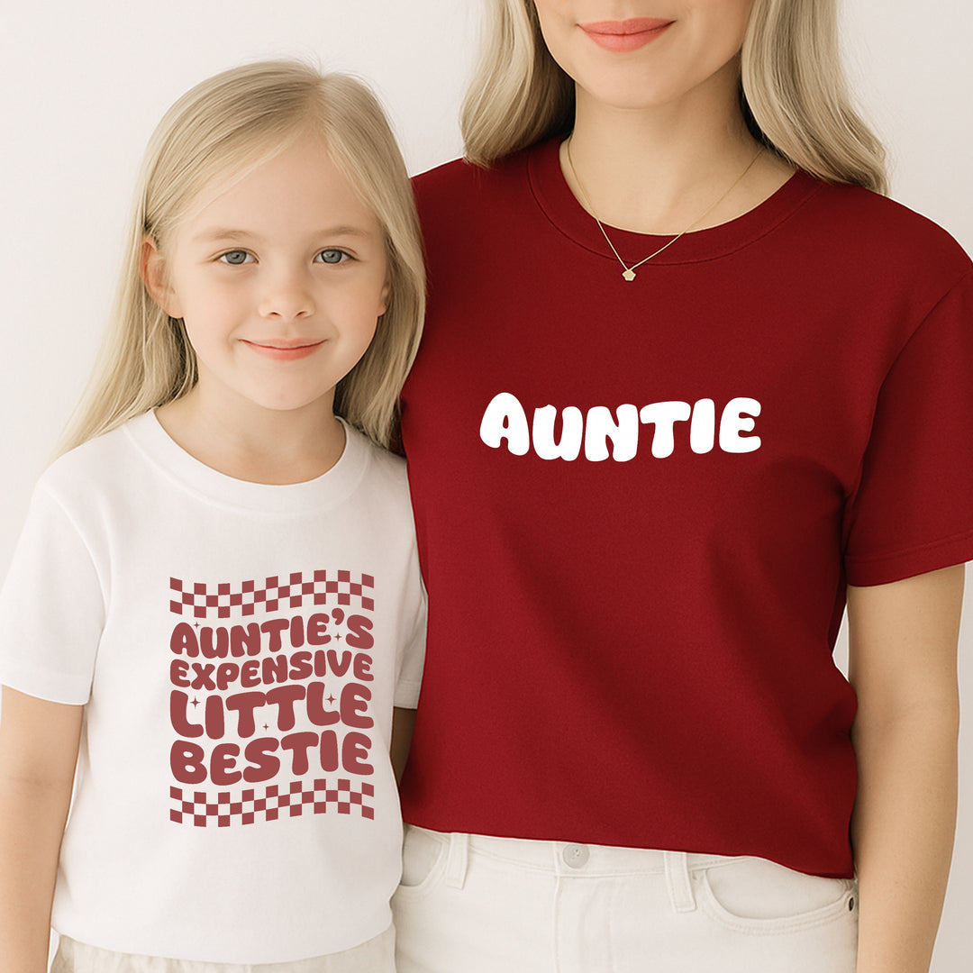 Two people wearing matching shirts with text, one red and one white.