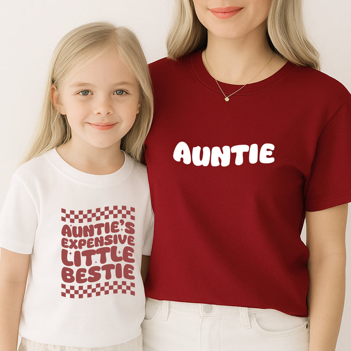 Two people wearing matching shirts with text, one red and one white.