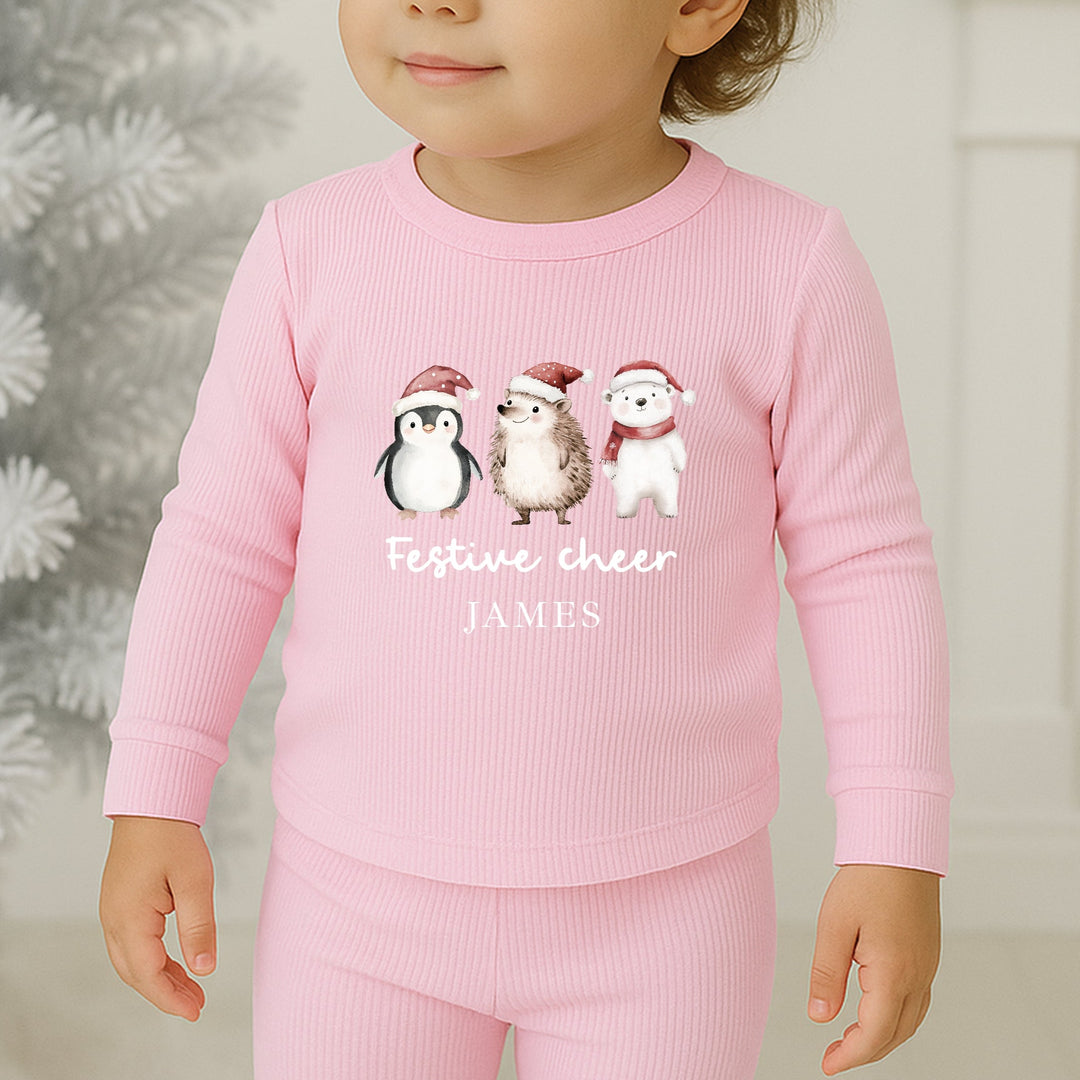 Child wearing pink pajamas with Christmas-themed design in a festive setting