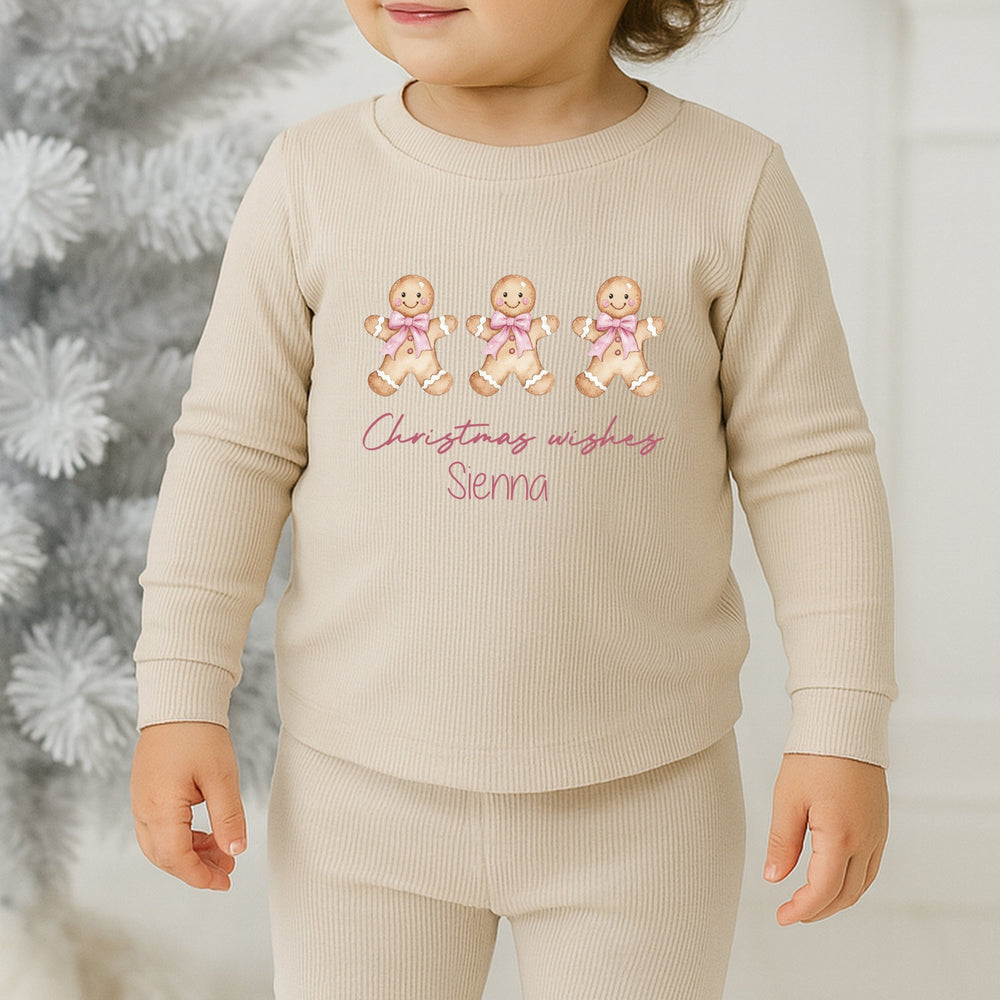 Child wearing a beige outfit with Christmas-themed design in a festive setting