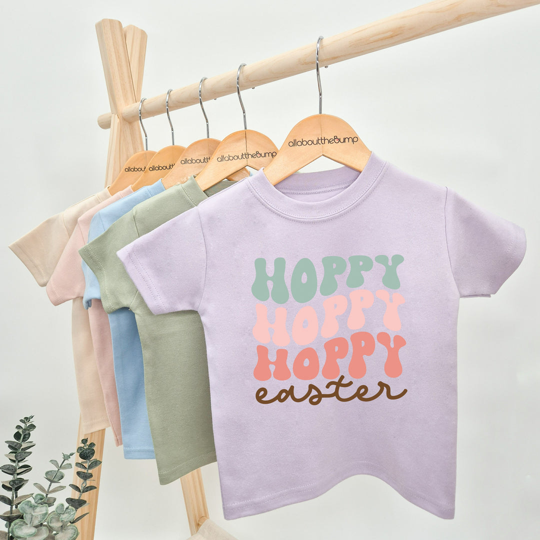 Lilac retro style Easter t-shirt that says 'Hoppy Easter'. This design features the word hoppy 3 times in 3 different colours stacked