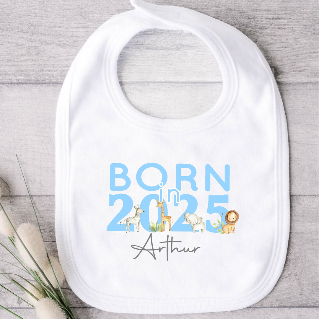 a personalised white baby bib  that says 'Born in 2025 Arthur'. This design features safari animals