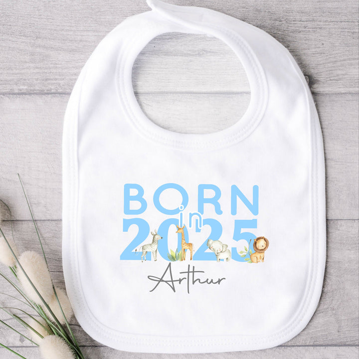 a personalised white baby bib  that says 'Born in 2025 Arthur'. This design features safari animals