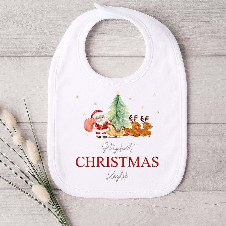 Baby bib with Christmas design and text on a wooden surface