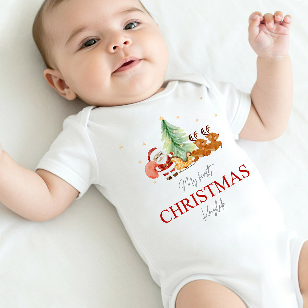 Baby wearing a 'My first Christmas' onesie with festive graphics.