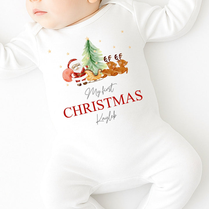 Baby wearing a white onesie with Christmas design and text on a white background