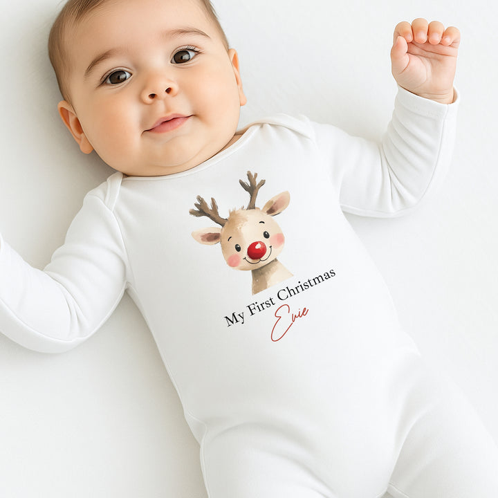Baby wearing a white onesie with a reindeer design and text on a white background