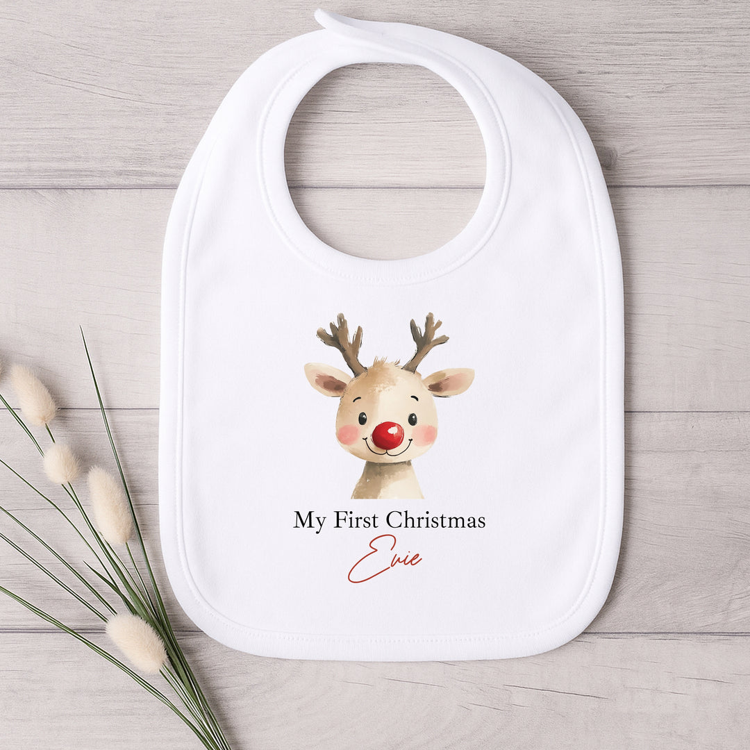 Baby bib with reindeer design and text on a wooden surface
