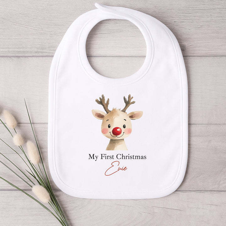 Baby bib with reindeer design and text on a wooden surface