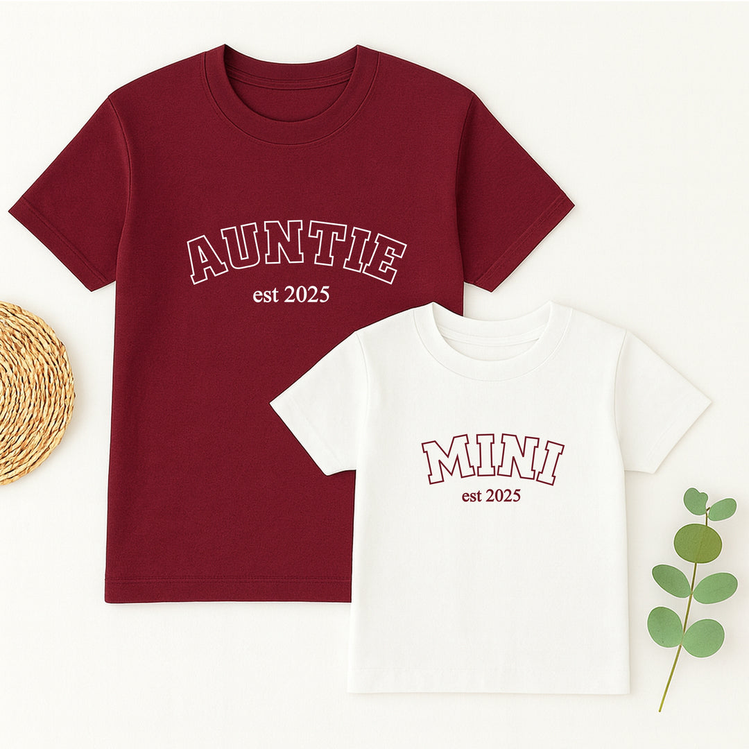 Two t-shirts, one maroon and one white, with 'Auntie est 2025' and 'Mini est 2025' text on a white background.
