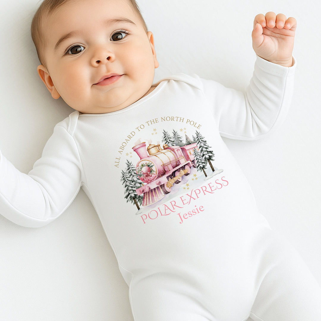 Baby wearing a 'Polar Express' themed onesie on a white background