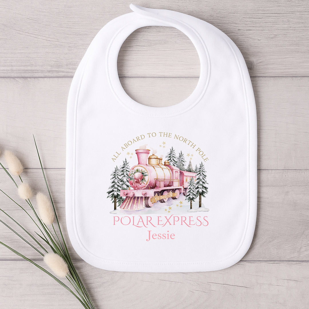 Baby bib with Polar Express design on a wooden surface